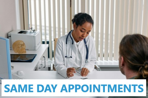 Middle aged female doctor with female patient sitting at office desk for a same day appointment