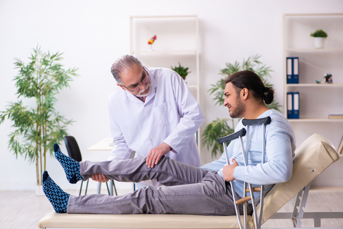 Picture of a person with e leg injury visiting a car accident doctors near me office.