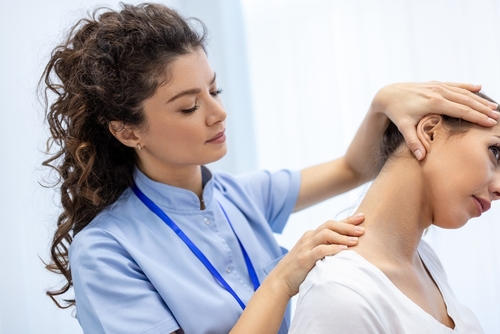 Physical Therapy Neck Treatment in Suffolk County, NY Physical therapist performing neck mobility assessment on female patient during a rehabilitation session.